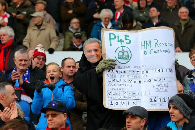 A Stoke City fan sporting a Jose Mourinho mask holds up a mock P45 for van Gaal. Picture: Getty Images