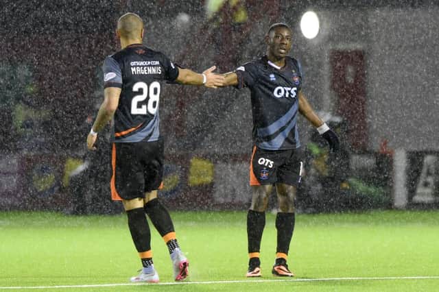 Josh Magennis congratulates Tope Odabeyi after he scored the only goal of the game at a rain-lashed New Douglas Park. Picture: SNS Group