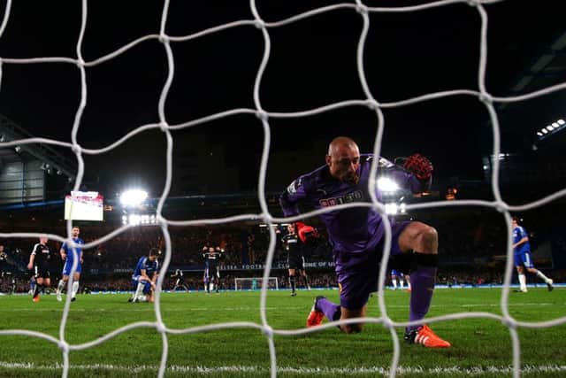 Watford 'keeper Heurelho Gomes celebrates as a dejected Oscar sinks to his knees in the background. Picture: Getty Images