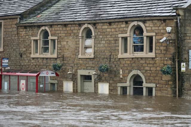 Residents look out fom their homes trapped by flood water as the River Calder bursts its banks in Mytholmroyd. Picture: Getty