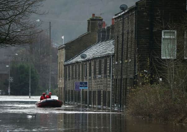 Rescue workers patrol the waters after the River Calder bursts its banks in Mytholmroyd. Picture: Getty Images