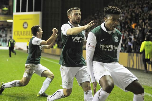 Dominique Malonga celebrates his late goal against Queen of the South, a crucial header which put Hibs level on points with Rangers. Picture: TSPL
