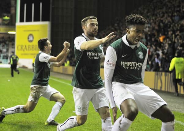 Dominique Malonga celebrates his late goal against Queen of the South, a crucial header which put Hibs level on points with Rangers. Picture: TSPL