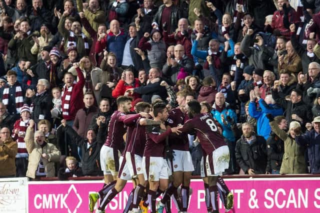 Hearts players mob Osman Sow after the Swedish striker's lsat-gasp equaliser. Picture: SNS Group