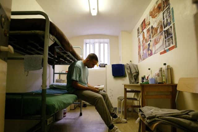 A prisoner reads a book in his cel (Photo by Ian Waldie/Getty Images)