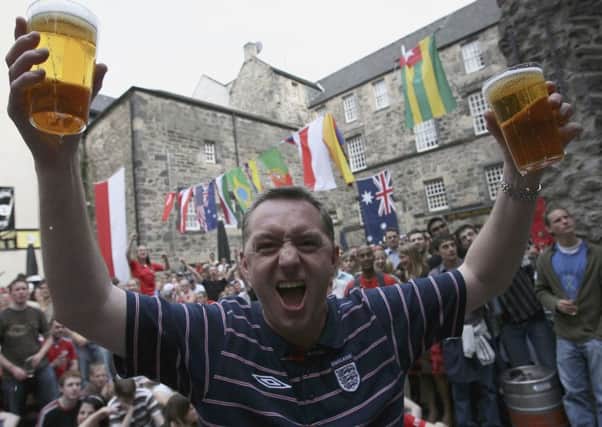 Trinidad and Tobago and England football fans react during a big screen viewing at the Three Sisters pub in Edinburgh. Photo by Jeff J Mitchell/Getty Images