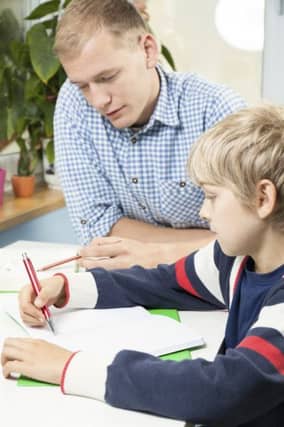 Little boy doing homework with father.