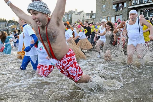 Members of the public wearing fancy dress enter the water as they join around 1,000 New Year swimmers, many in costume, in front of the Forth Rail Bridge during the annual Loony Dook Swim in the River Forth on January 1, 2014 in South Queensferry Picture: Jeff J Mitchell/Getty Images