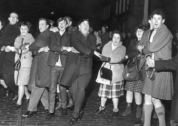 People singing Auld Lang's Syne during New Year at the Tron, Edinburgh 1964.