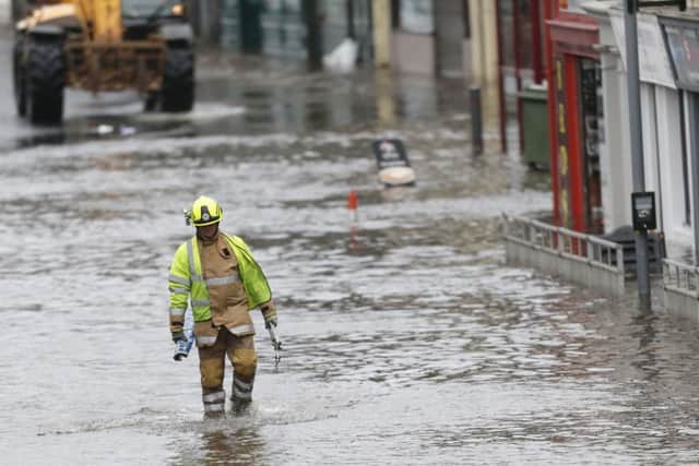 A fire officer wades through flood water in Newton Stewart. Picture: PA