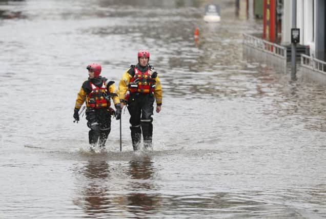 Rescue workers wade through flood water in Newton Stewart. Picture: PA