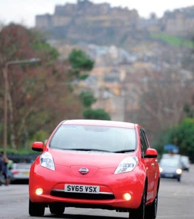 Douglas Robertson of EVAS with his red Nissan Leaf electric car.

 Picture: Neil Hanna