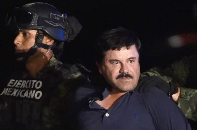 Drug kingpin Joaquin El Chapo Guzman is escorted into a helicopter at Mexico Citys airport. Picture: AFP/Getty Images