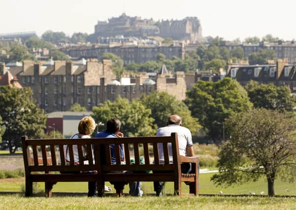 Taking in a view of Edinburgh Castle whilst enjoying the warm weather in Inverleith Park in Edinburgh. Picture: TSPL