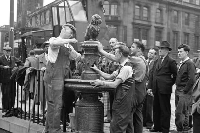 Statue of Greyfriars Bobby being replaced on pedestal after it was knocked off its pedesta.