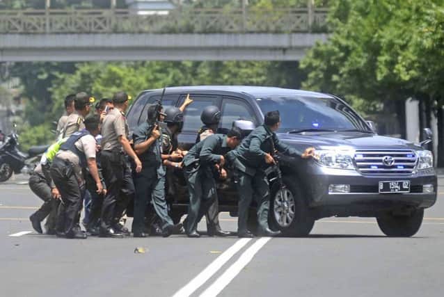 Police in Jakarta take cover during a gun battle with terrorists in the Indonesian capital. Picture: AP