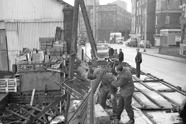 Workmen tear down damaged railings after the January gales in Edinburgh in 1968.
