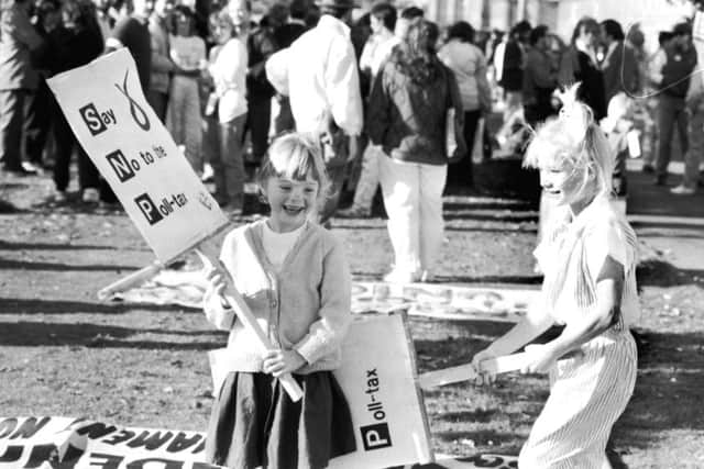 Sally Dredge from Currie and Dawn McDiarmid play with their anti-poll tax banners ('SNP Say No to the Poll-Tax) during a demonstration at Sighthill in Edinburgh, October 1989. Image: TSPL