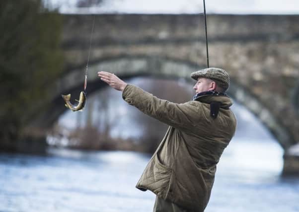 An angler catches a brown trout on the River Tay in Kenmore, Scotland, on the opening day of the salmon fishing season. Picture: PA