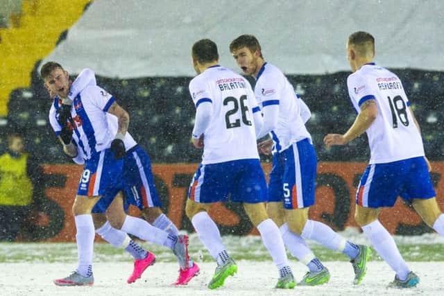 Craig Slater is mobbed by his team-mates after scoring the winner. Picture: SNS Group