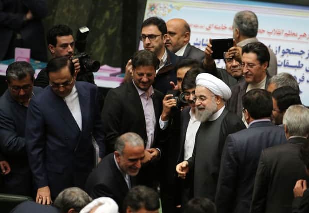 Hassan Rouhani, in white headdress, arrives at Tehrans parliament to present the proposed annual budget yesterday after nuclear sanctions were lifted. Picture: AFP/Getty