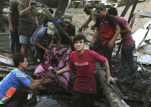 A body is carried away after a truck bombing in Sadr City, Iraq. Picture: AP