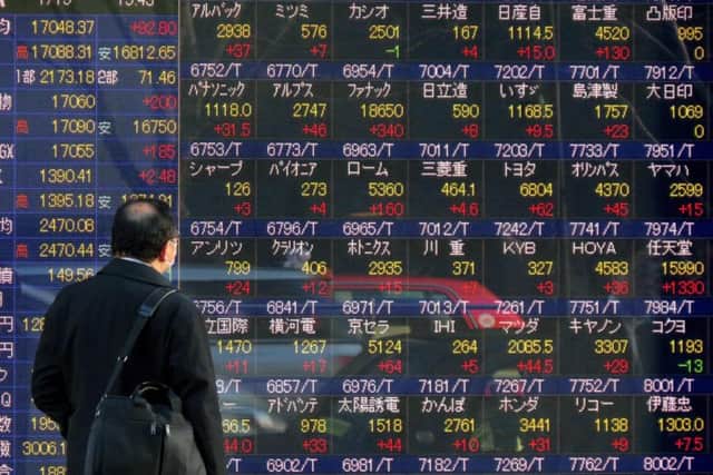 A man looks at stock exchange figures, revealing Chinas full-year growth dropped to 6.9 per cent. Picture: AFP/Getty Images