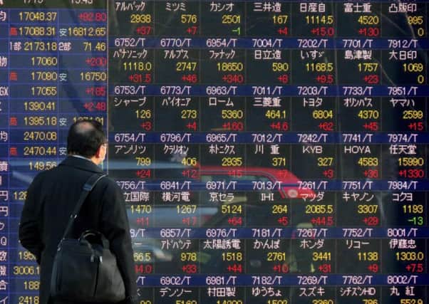 A man looks at stock exchange figures, revealing Chinas full-year growth dropped to 6.9 per cent. Picture: AFP/Getty Images
