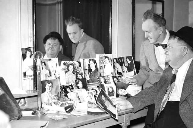Laurel and Hardy - At Empire Theatre, Edinburgh looking at  photographs of entries for Evening Dispatch Lovely Shopgirl competition.