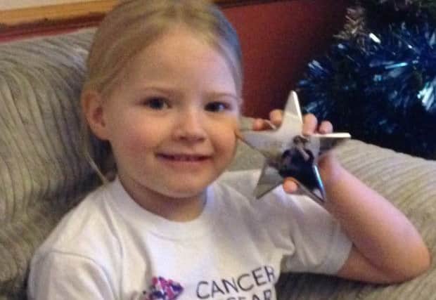 Four-year-old Nicole Millar shows off her Cancer Research UK Kids & Teens Award for bravery.