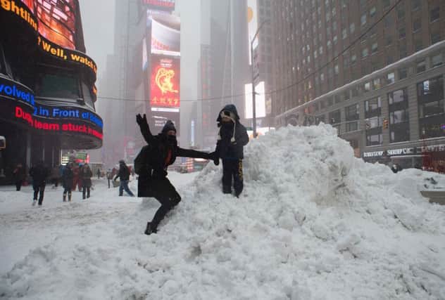 A woman posing for a photograph on a pile of snow in Times Square. Picture: AFP/Getty