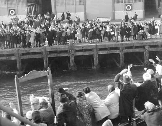 Friends and relatives wave goodbye from the Greenock quayside as Scottish emigrants depart in April 1967. Picture: Gordon Rule/TSPL