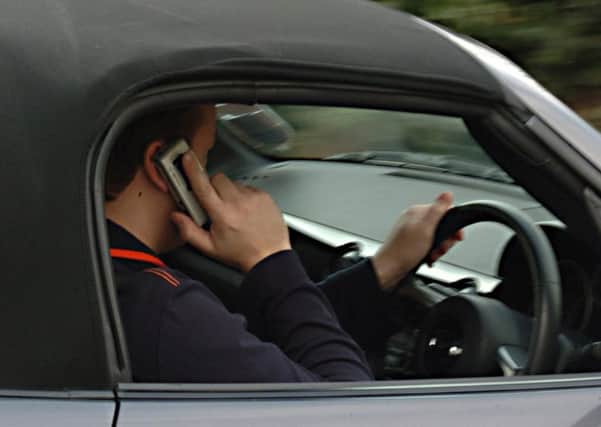 A man using his mobile phone while driving. Picture: PA
