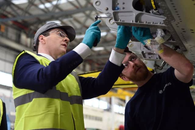 Chancellor George Osborne helps Airbus employee Sam Thurlow fix a part to a wing for an Airbus A400M during a visit to the Airbus factory in Filton, Bristol. Picture: Andrew Matthews/PA Wire