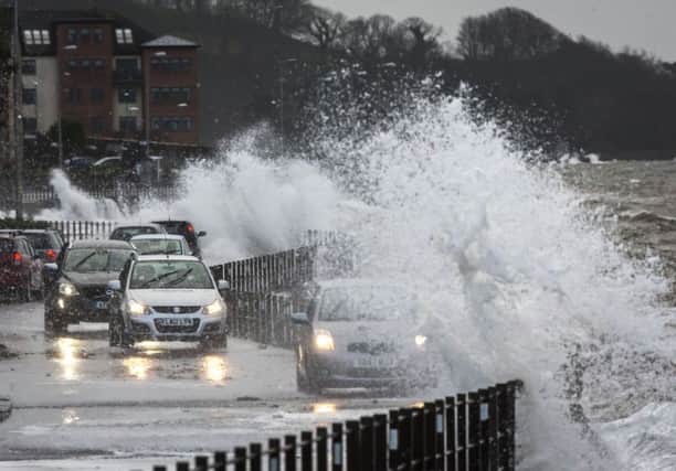 Waves break over a coastal road in Skelmorlie. Picture: PA