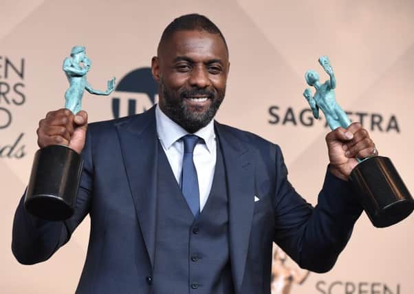 Idris Elba holds awards won for Beasts Of No Nation and Luther. Picture: AP
