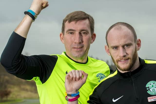 Alan Stubbs and Hibs captain David Gray wore unity bands at training yesterday to promote World Cancer Day on Thursday. Picture: SNS