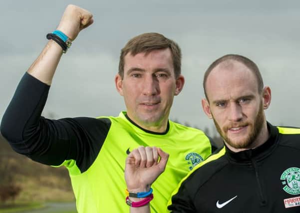 Alan Stubbs and Hibs captain David Gray wore unity bands at training yesterday to promote World Cancer Day on Thursday. Picture: SNS