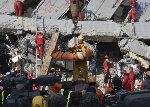 A rescue worker brings down a victim from the collapsed Wei Kuan building in Taiwan. Picture: Getty