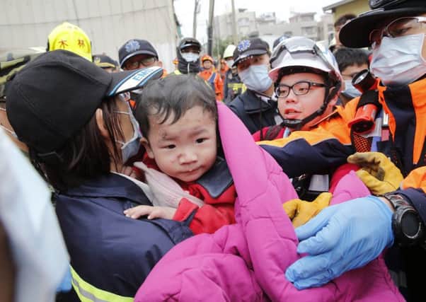 Rescue workers (central) look for survivors in the remains of a building which collapsed in the 6.4 magnitude earthquake. Picture: AFP/Getty Images