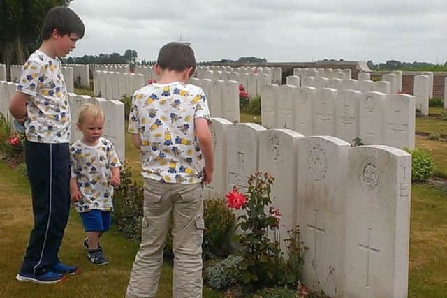 Donald Walker's children in ArnÃ¨ke British Cemetery, at the grave of their great grandfather Sapper John McDonald