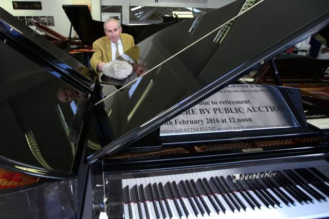 James Cameron of the Edinburgh Piano Company polishes pianos in the firm's showroom in Edinburgh ahead of an auction on Sunday. Picture: PA