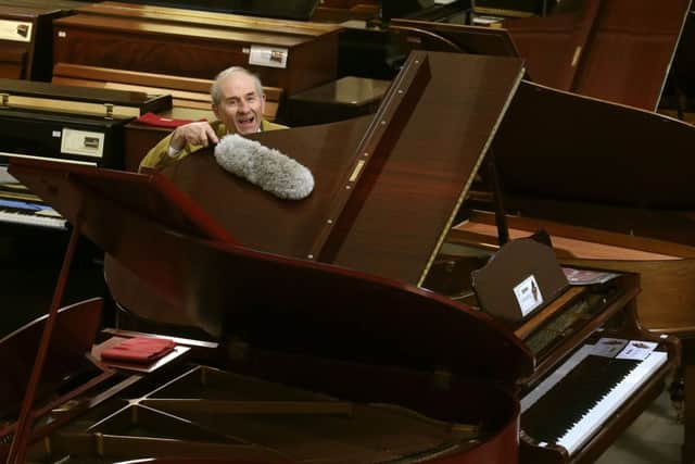 James Cameron of the Edinburgh Piano Company polishes pianos in the firm's showroom in Edinburgh ahead of an auction on Sunday. Picture: PA