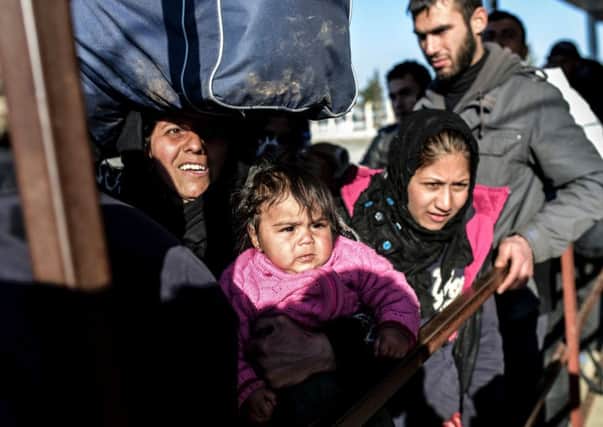 Syrian families line-up waiting to go back to Syria at the Turkish Oncupinar border gate near Kilis. Picture: AFP
