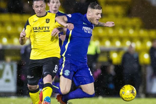 Hibs' Anthony Stokes is tackled by Livingston's Mark Fotheringham. Picture: Ross Parker/SNS