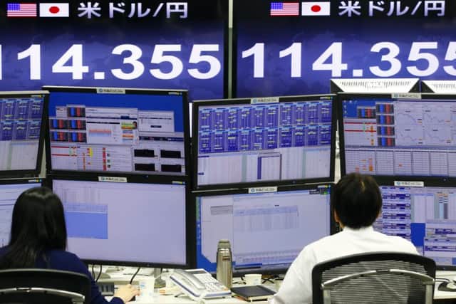Money traders work in front of the computer terminal at a foreign exchange brokerage in Tokyo. Picture: AP