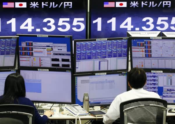 Money traders work in front of the computer terminal at a foreign exchange brokerage in Tokyo. Picture: AP