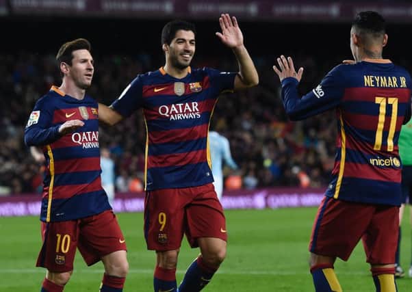 Lionel Messi (left) and Luis Suarez celebrate a goal with fellow forward Neymar. Picture: AFP/Getty Images