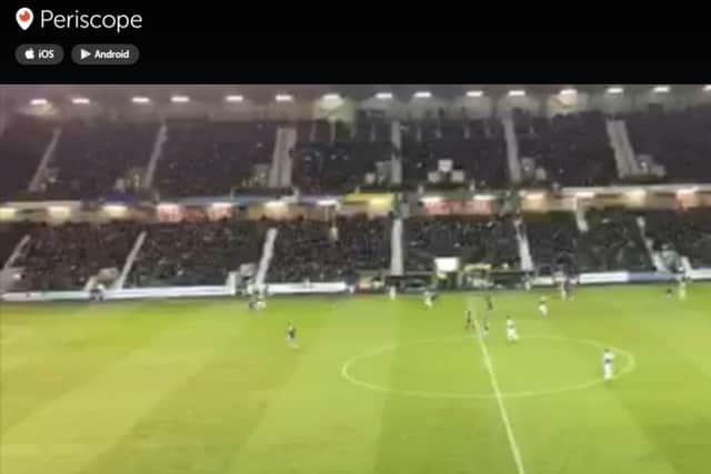 A Hibs fan in the East Stand broadcasts the action