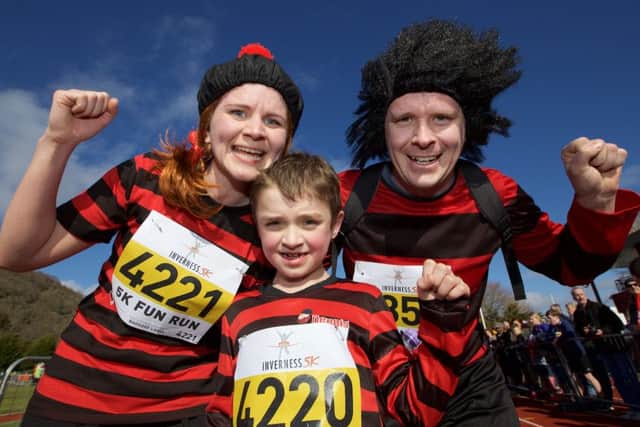 Dennis the Menace team of Jenny Roberts, Joel Sleet & Daniel Roberts celebrate crossing the together in the Inverness 5K run and Half Marathon.